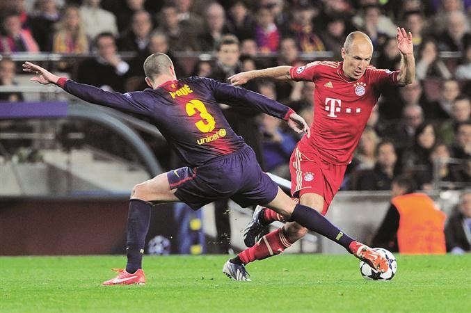 لاعب وسط بايرن ميونيخ اريين روبن يمر من مدافع برشلونة جيرار بيكيه 	افپ﻿