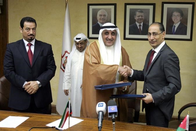 عبد الوهاب البدر وابراهيم سيف يتبادلان بنود الاتفاق بحضور د حمد الدعيج 