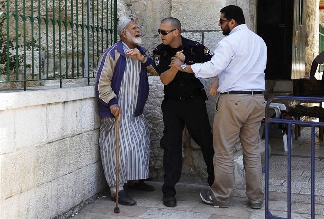 شرطي اسرائيلي يمنع فلسطيني مسن من دخول المجمع الذي يضم المسجد الاقصى رويترز﻿