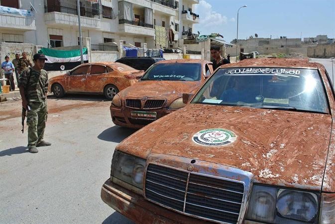 مقاتلو الجيش السوري الحر يقودون سيارات مموهة بالطين خلال توجههم لمعركة مطار منغ العسكري في حلب امس الاول افپ 
