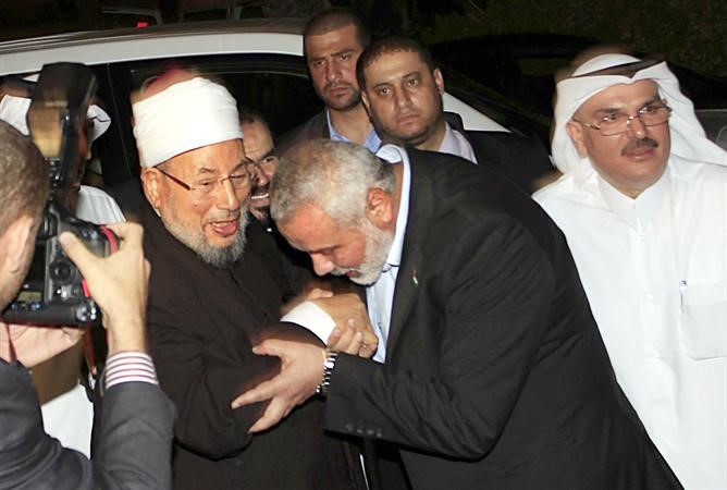 رئيس وزراء الحكومة الفلسطينية المقالة اسماعيل هنية يقبل يد الشيخ يوسف القرضاوي في غزة ا ف پ
