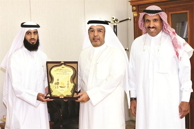 النائب ناصر المري يتسلم درعا من الشيباني والى جانبه ناصر العجمي﻿