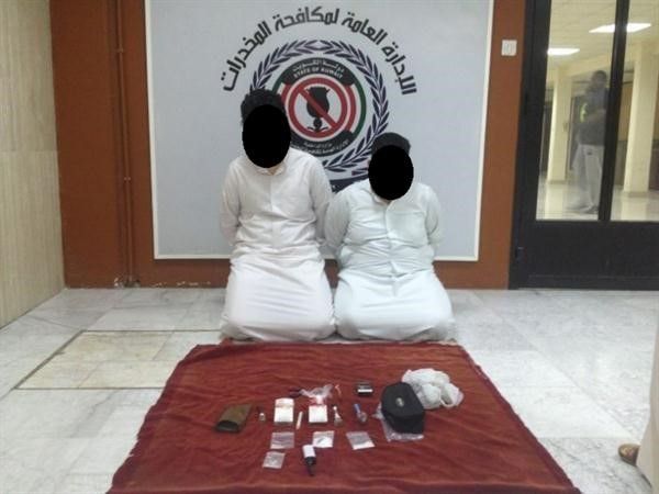 المتهمان في مقر المكافحة وامامهما المضبوطات
