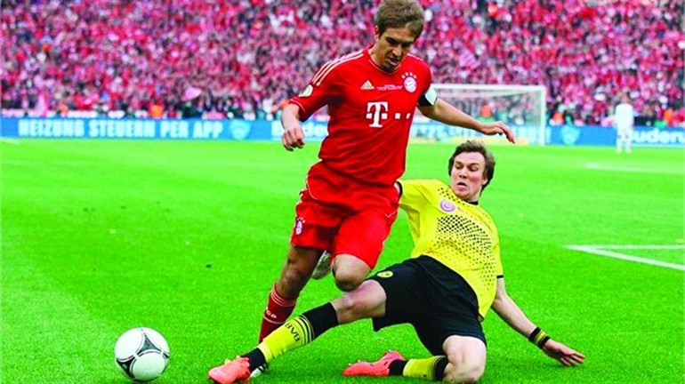 مدافع بايرن لام يمر من لاعب دورتموند في مباراة سابقة