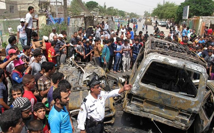عراقيون يعاينون موقع انفجار سيارة مفخخة في مدينة الصدر في بغداد امس الاول رويترز