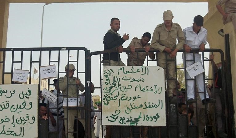 مجندونعلى الجانب المصري من معبر رفح الحدودي يرفعون لافتات تطالب بعودة زملائهم المخطوفين امسافپ