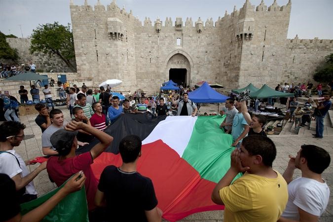 محتجون يحملون العلم الفلسطيني امام بوابة دمشق في القدس المحتلة امس الاول	افپ