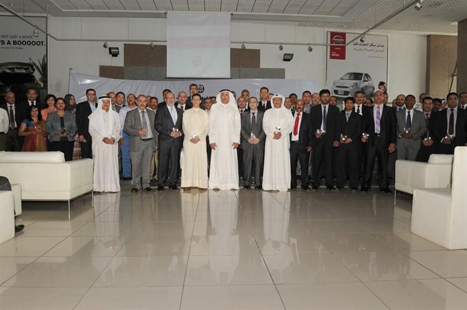 صالح البابطين يتوسط الموظفين المكرمين في مجموعة البابطين