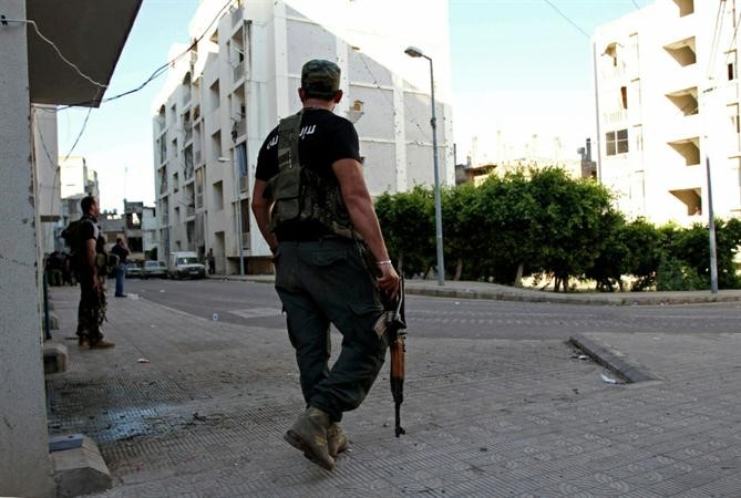 مسلحون يتجولون في شارع القبة في طرابلس بعد اشتباكات ليلية مع جبل محسن محمود الطويل
