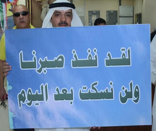 موظف يرفع لافتة خلال الاعتصام