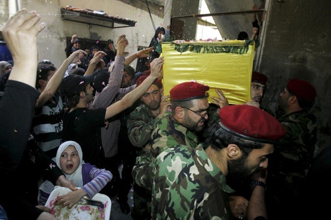 لبنانيون ينثرون الارز على جثمان احد مقاتلي حزب الله قتل في المعارك ضد الجيش الحر بالقصير رويترز