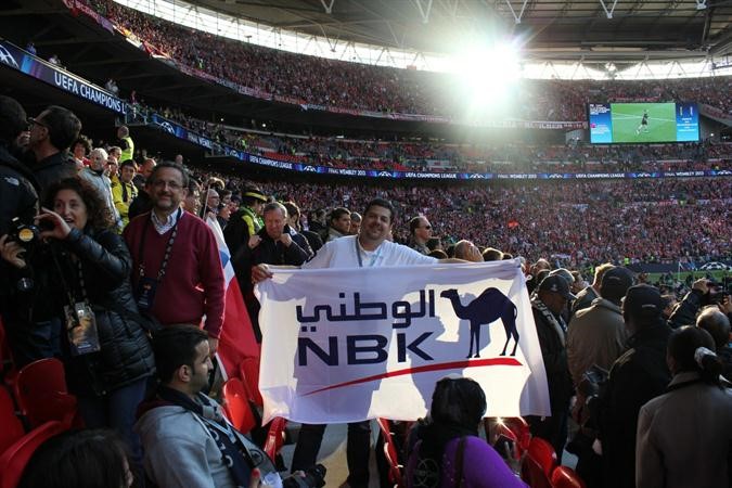 جلبير خلال مشاهدة احدى المباريات حاملا شعار الوطني