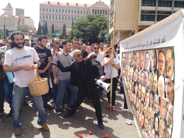 معارضون للتمديد يرشقون صورة للنواب كتب عليها فشلتم في كل شيء بالطماطم