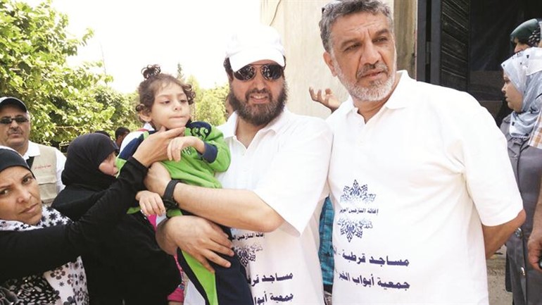 خالد الصبيحي يحمل طفلة مريضة