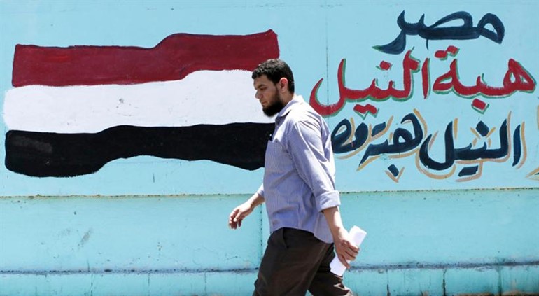  مواطن مصري يسير بجوار لوحة جدارية تشير الى ان مصر هبة النيل رويترز