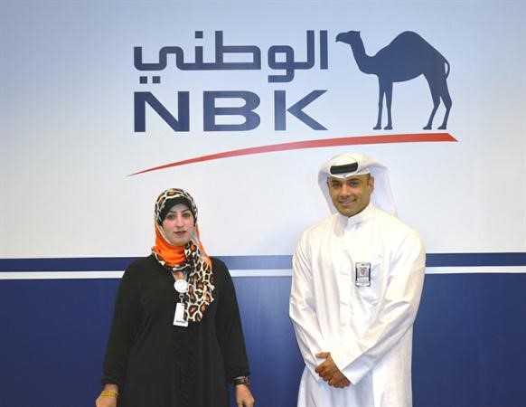 مسؤول العلاقات العامة في بنك الكويت الوطني احمد المحميد وخبيرة لغة الاشارة في البنك نجاة مختار