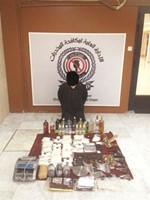 المتهمة وامامها كوكتيل المخدرات والاسلحة النارية