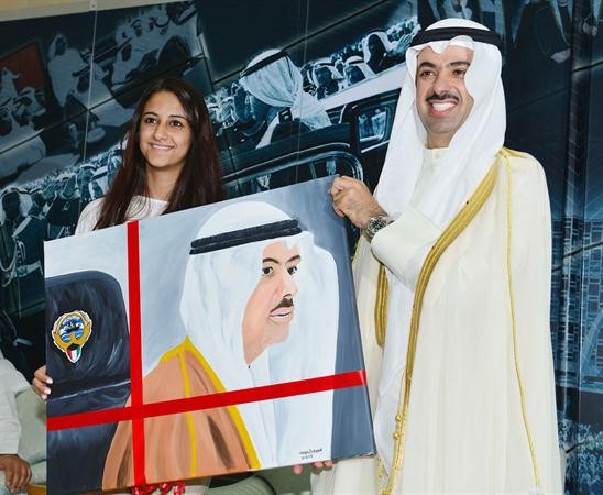 الراشد يتسلم لوحة رسمتها احدى العاملات