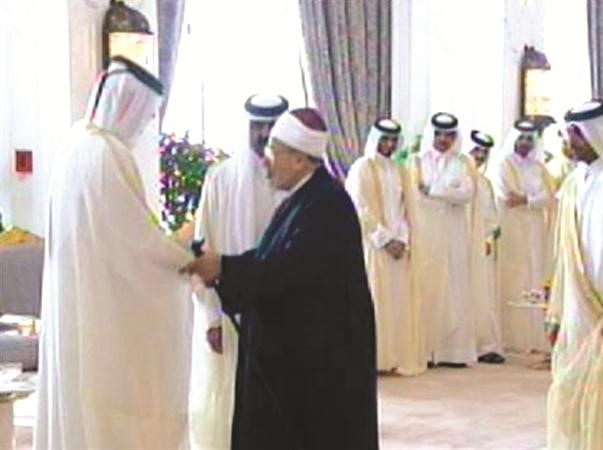 صورة تلفزيونية للشيخ يوسف القرضاوي وهو يصافح امير قطر السابق الشيخ حمد بن خليفة