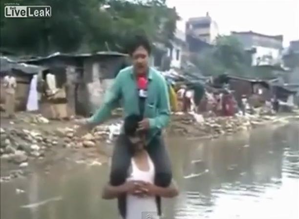 بالفيديو.. مراسل هندي يلقي تقريره عن الفيضانات وهو يجلس على أكتاف شخص