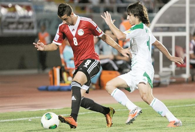 العراقي همام طارق يحاول استخلاص الكرة من المصري متولي محمود 