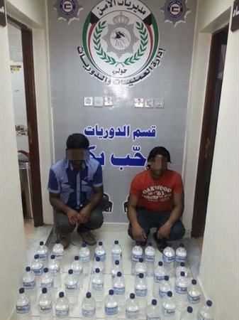 الاسيويان وامامهما الخمور المضبوطة﻿