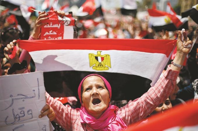 سيدة عجوز ترفع علم مصر في مظاهرات ميدان التحرير المطالبة برحيل الرئيس مرسي رويترز