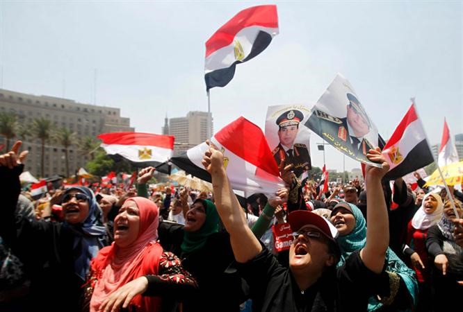 مواطنون يلوحون باعلامهم ويرفعون صورا للسيسي في ميدان التحرير امس رويترز