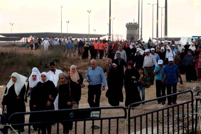  فلسطينين يعبرون نقطة تفتيش قلنديا في طريقهم لاداء صلاة الجمعة بالاقصى امس اب 