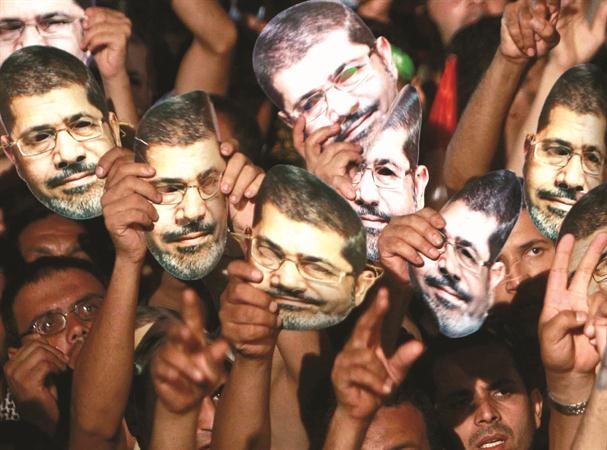 مؤيدو الرئيس المصري المعزول محمد مرسي يحملون اقنعة له خلال اعتصام رابعة العدوية الجمعةرويترز
