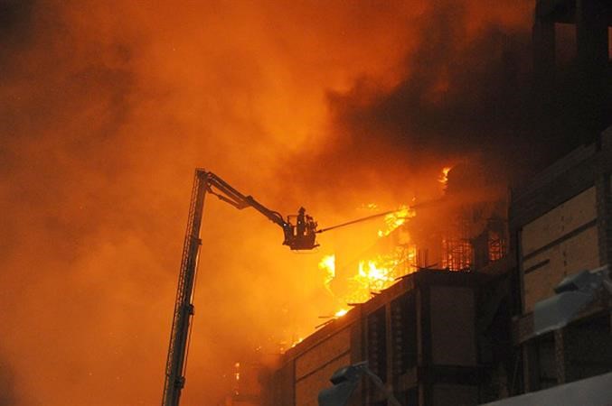 رجال الاطفاء يتعاملون مع الحريق من خلال السلالم المتحركة﻿