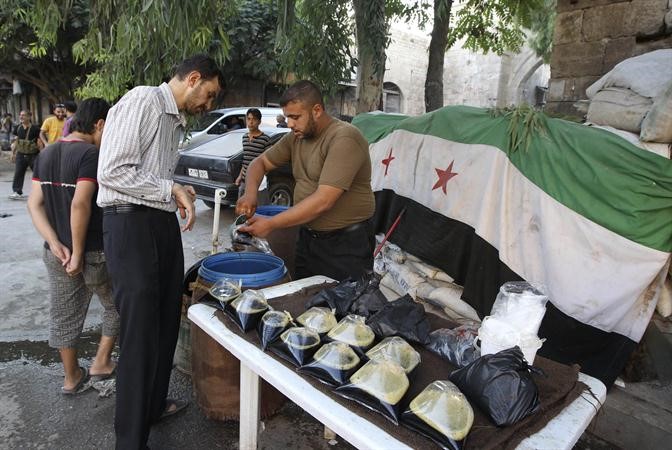 بائع متجول يبيعالعرق سوسقبل الافطار في احد احياء حلب الواقعة تحت سيطرة المعارضة في حلب 	 رويترز ﻿