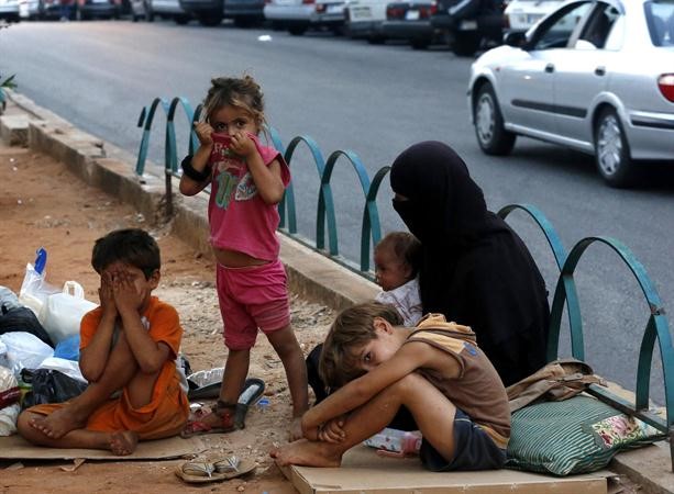 سيدة سورية واطفالها يفترشون الطريق في بيروت بعد ان فرت من القصف والدمار في سورية رويترز