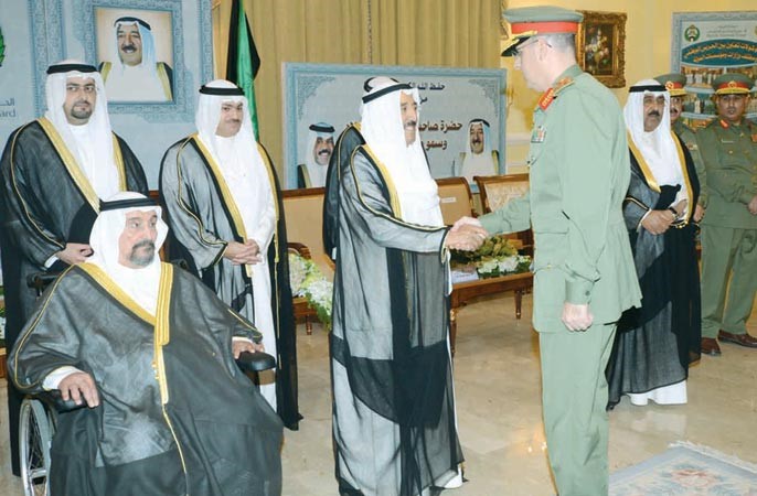 صاحب السمو الامير الشيخ صباح الاحمد مصافحا احد ضباط الحرس الوطني بحضور سمو الشيخ سالم العلي والشيخ مشعل الاحمد