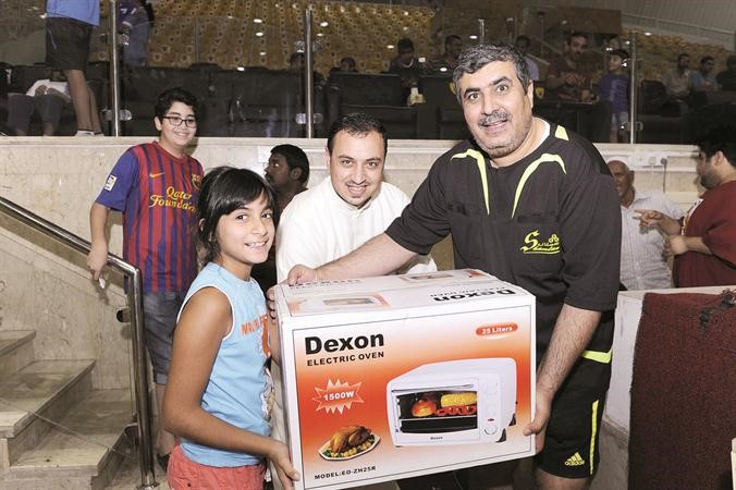 الحكم صالح مهدي يقدم الجائزة للطفلة الفائزة بالسحب