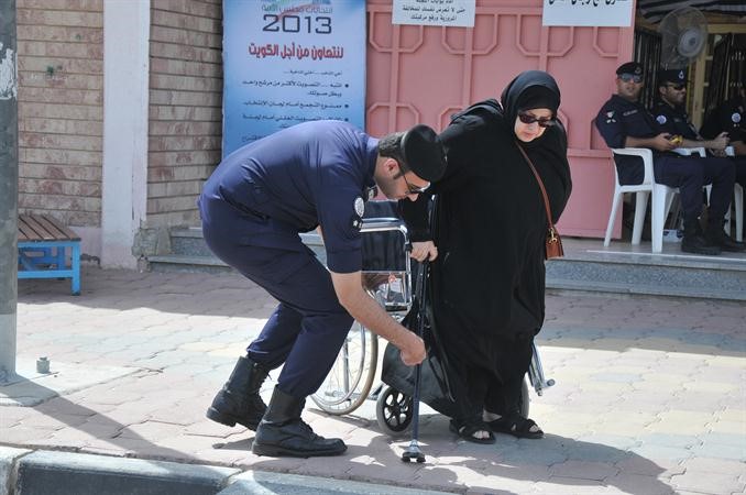 احد رجال الداخلية يساعد احدى كبيرات السن