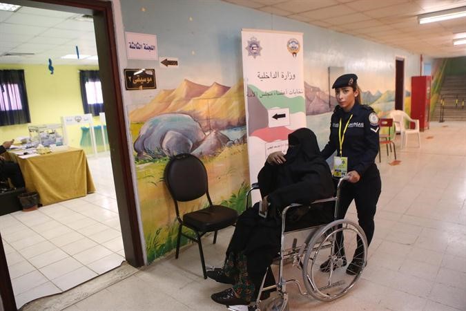 احدى عناصر الشرطة النسائية تساعد احدى كبيرات السن

