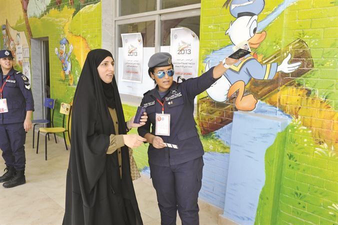 احدى عناصر الشرطة النسائية ترشد ناخبة الى لجنة التصويت