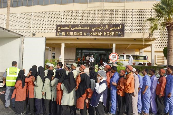 فريق العلاقات العامة لدى الوطني خلال توزيع وجبات الافطار في منطقة الصباح الطبية ﻿