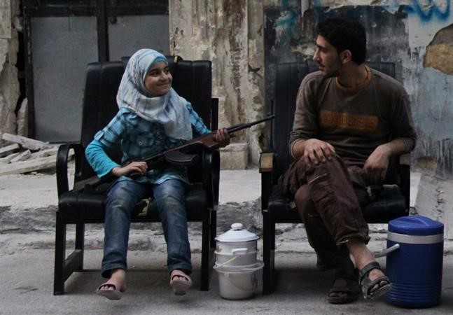 فتاة تحمل السلاح وبجانبها عنصر من الجيش الحر في حلب رويترز
