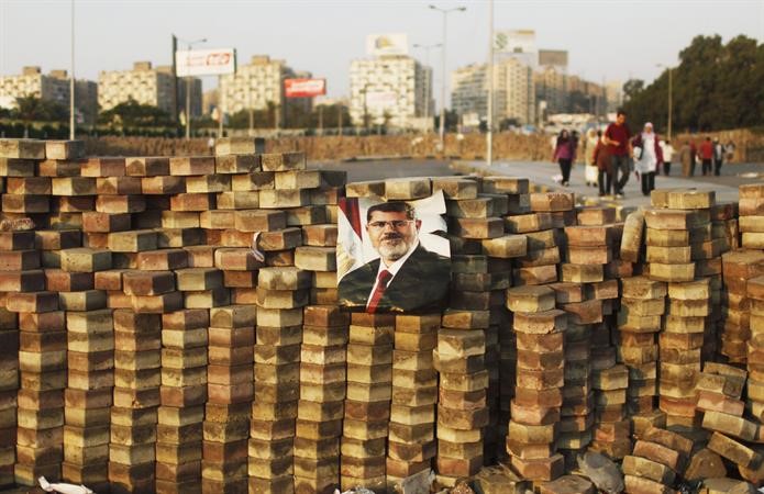 مؤيدو مرسي يضعون صورته فوق حاجز بنوه بالقرب من ميدان رابعة العدوية رويترز
