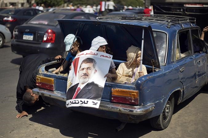 اطفال في صندوق سيارة يحملون صورا للرئيس المعزول محمد مرسي امس الاول افپ