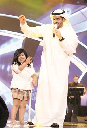 الجسمي مع طفلة من الحضور اثناء الحفل﻿