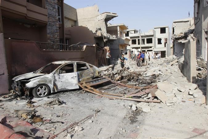 عراقيون يعاينون موقع انفجار سيارة مفخخة في كركوك امس الاول 	رويترز﻿