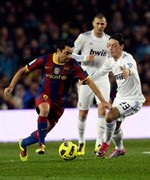 تشافي هيرنانديز محاولا المرور من لاعب مدريد مسعود اوزيل 
