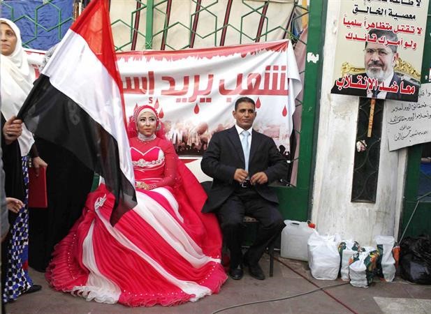 عروسان من انصار الرئيس المعزول محمد مرسي عقب عقد قرانهما في اعتصام رابعة امس الاول رويترز