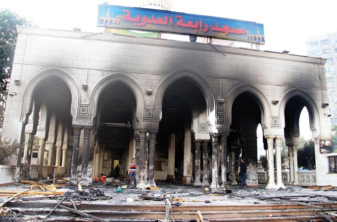 مصريون يعاينون اثار احتراق مسجد رابعة العدوية بفعل فض الامن اعتصام انصار الرئيس مرسي امس الاول اپ
