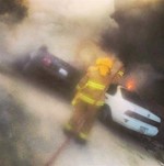 احد رجال الاطفاء خلال اخماد حريق مركبتين﻿