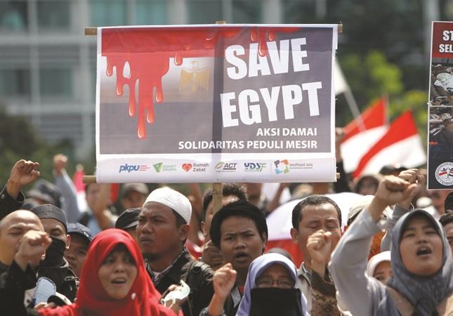 متظاهرون اندونيسيون بجاكرتا امسيرفعون لافتة تدعو لوقف العنف في مصر اب 