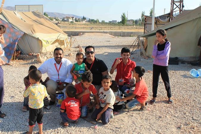 اعضاء من اتحاد اميركا خلال تقديم المعونات والهدايا للاطفال السوريين 